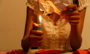 Девушка сжигает листочек