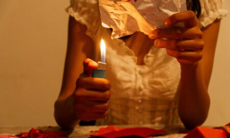 Девушка сжигает листочек