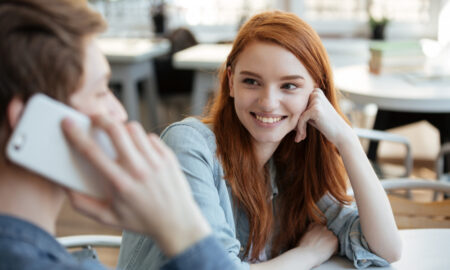 Рыжеволосая девушка и парень в кафе