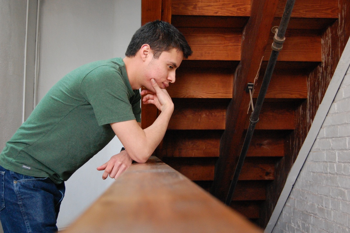 Мужчина в зеленой футболке думает