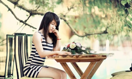 Девушка сидит за столом и думает