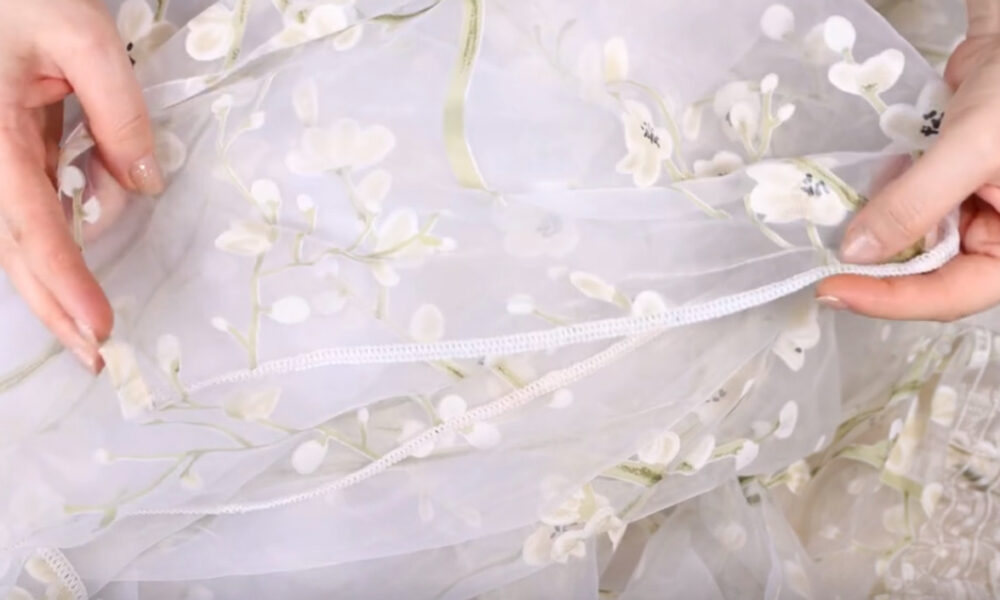 Женщина держит тюль в руках