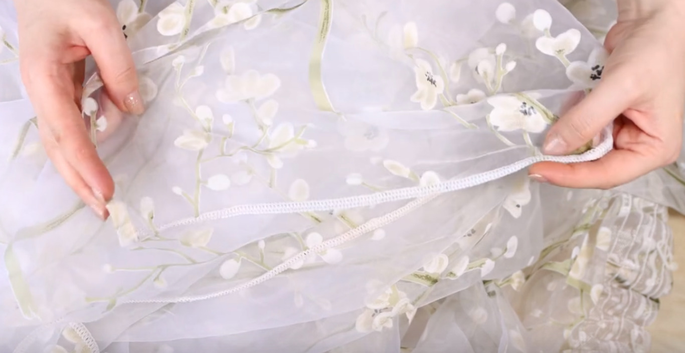 Женщина держит тюль в руках