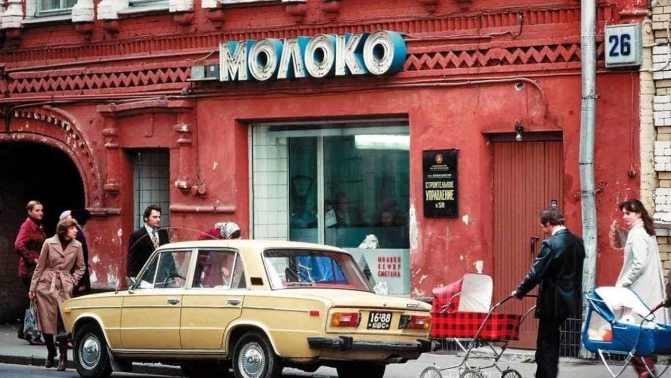 Люди и автомобиль рядом с молочным магазином