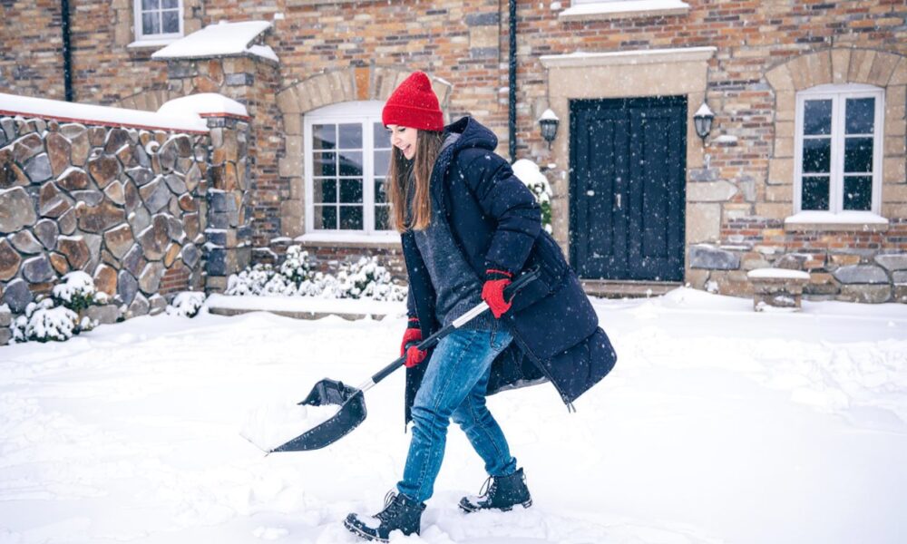 Девушка чистит снег