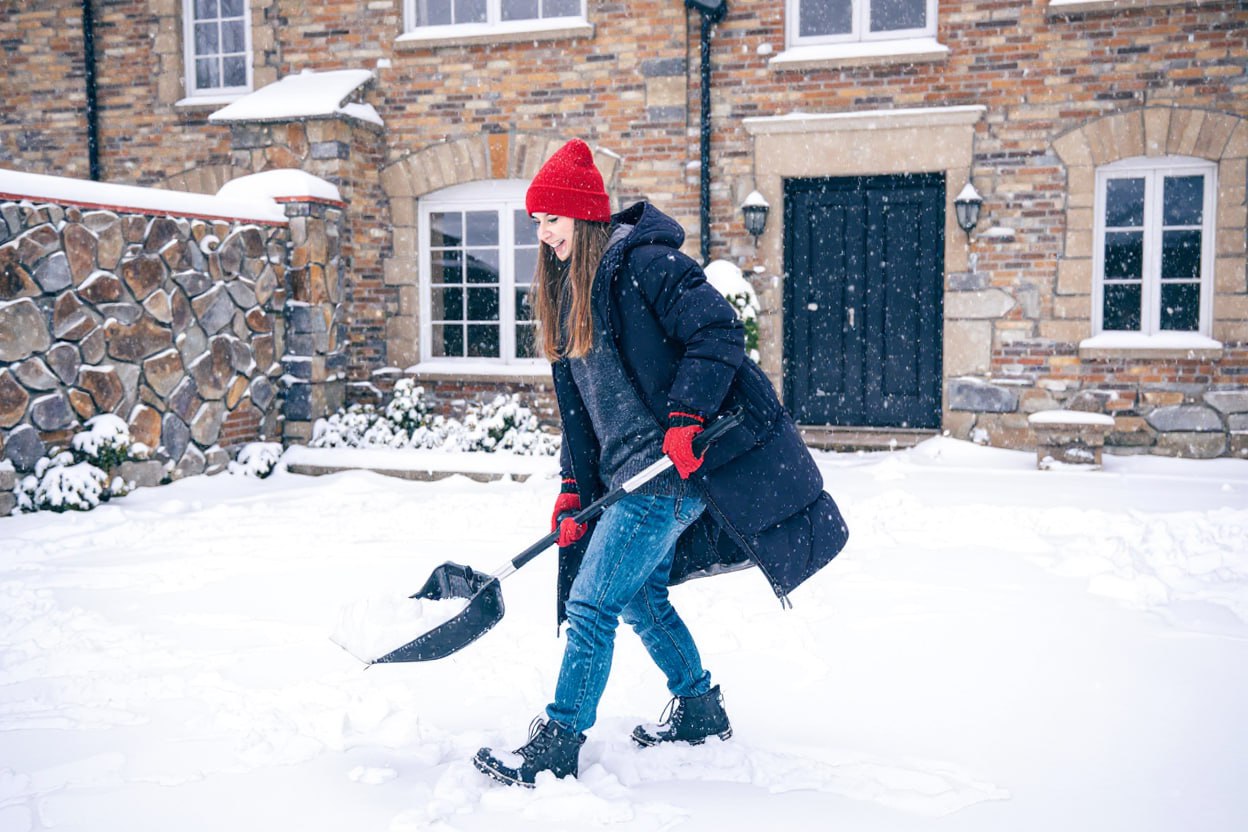 Девушка чистит снег