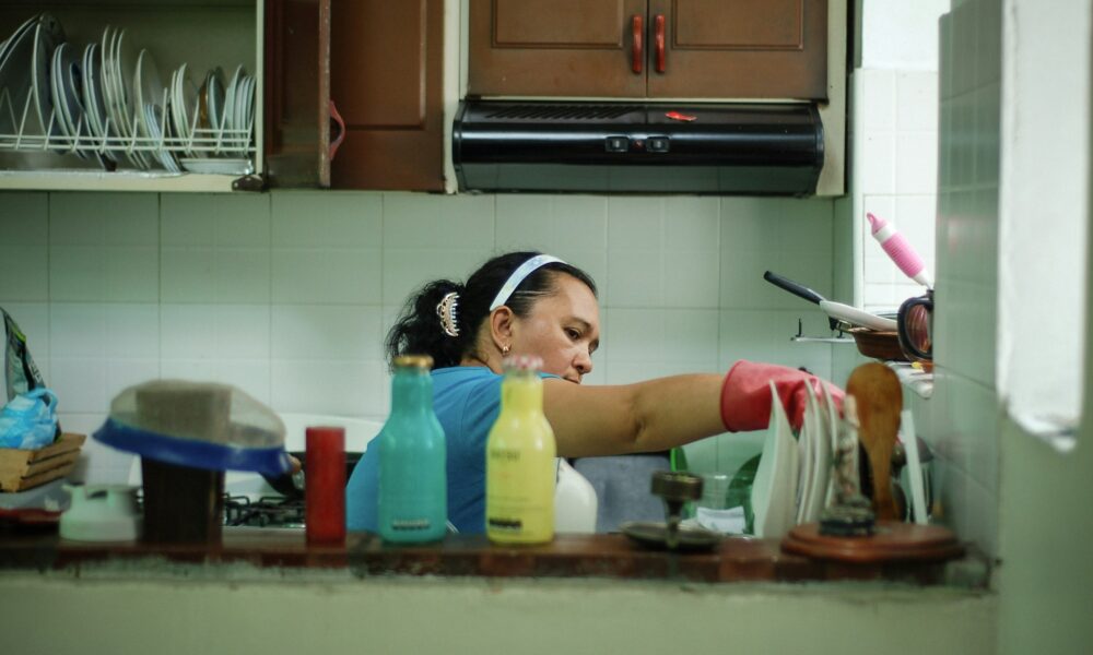 Женщина моет посуду