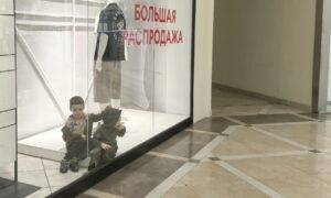 Дети за стеклом с надписью Распродажа