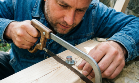 Мужчина режет болт ножовкой