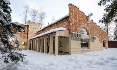 здание отеля, вокруг которого много снега