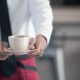 Официант с чашкой кофе