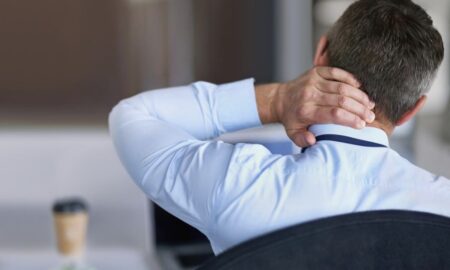 мужчина держится за шею