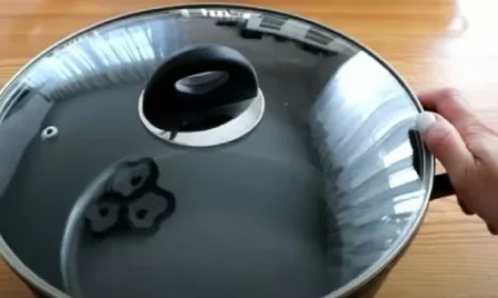 Человек держит рукой кастрюлю