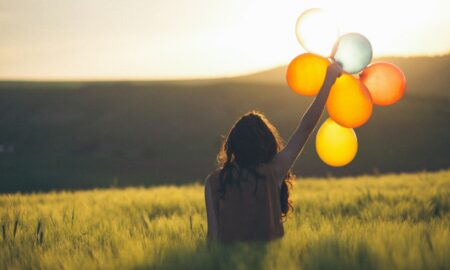 Девушка в поле с воздушными шарами
