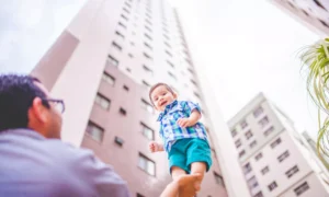 Отец держит рукой ребенка