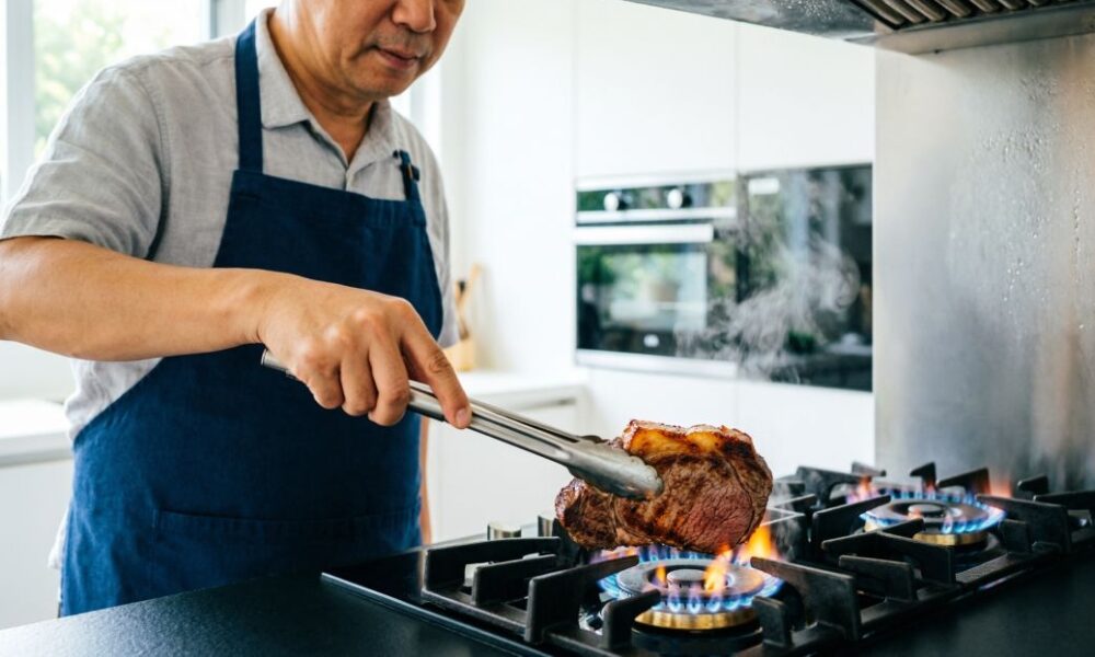 Мужчина жарит мясо