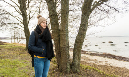 Девушка прогуливается по берегу водоема весной