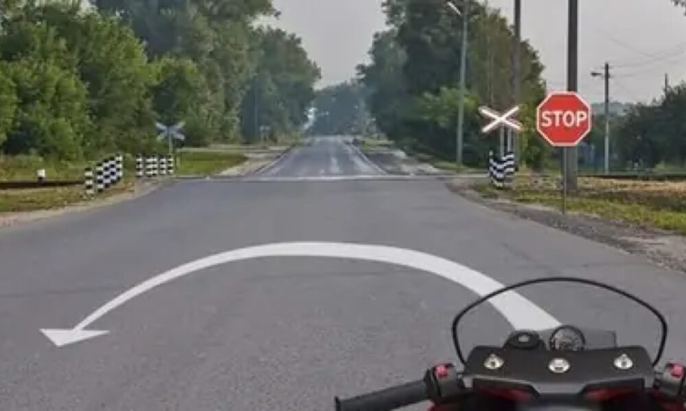 Мотоцикл на дороге рядом со знаком