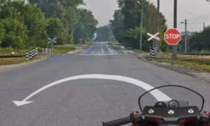 Мотоцикл на дороге рядом со знаком