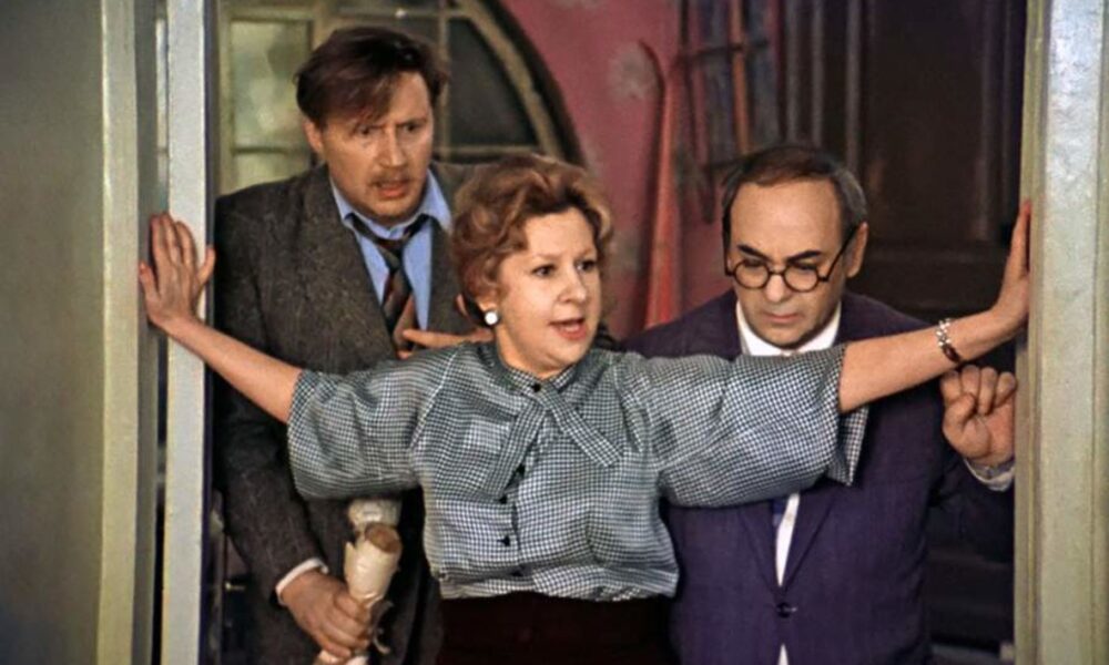 Двое мужчин и женщина стоят в дверном проеме