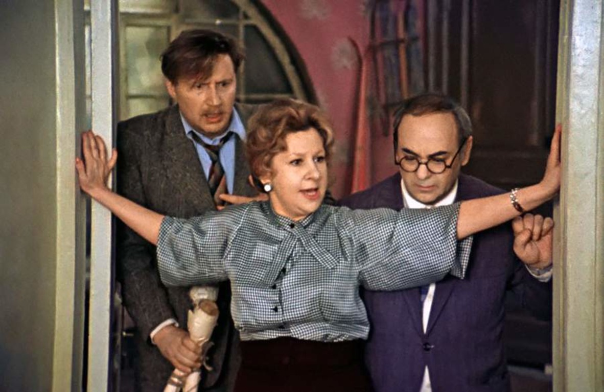 Двое мужчин и женщина стоят в дверном проеме