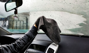 Мужчина протирает лобовое стекло