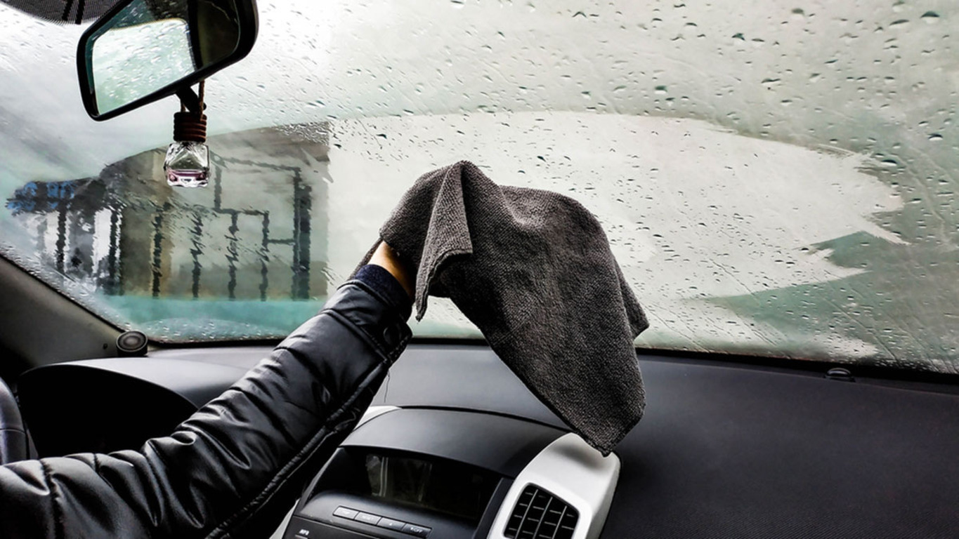 Мужчина протирает лобовое стекло