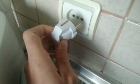 вытаскивает из розетки вилку