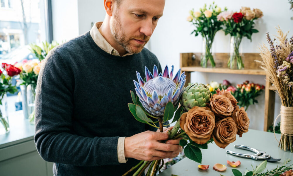 Мужчина собирает букет на 8 Марта
