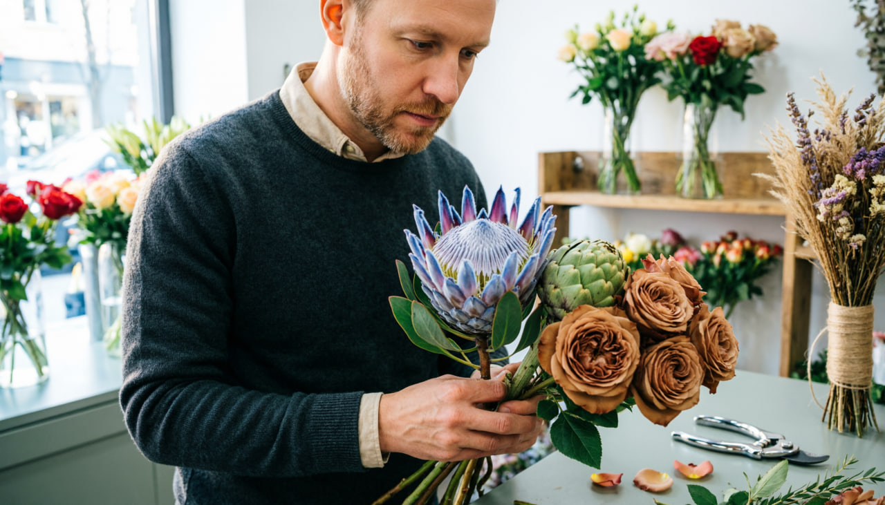 Мужчина собирает букет на 8 Марта