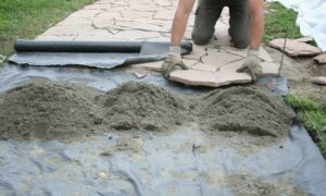 Рабочий укладывает садовую дорожку