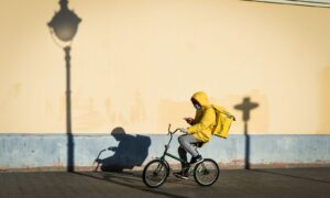 Курьер в желтом на велосипеде