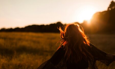 Девушка в поле на фоне заката