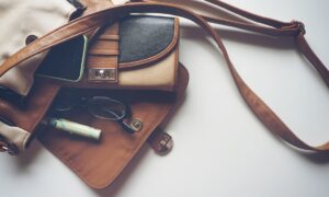 Женская сумка и очки лежат на столе