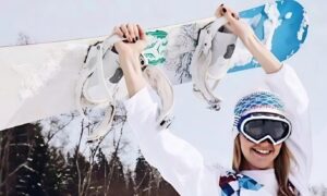 Счастливая сноубордистка с доской в руках