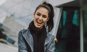 Женщина в темной куртке радуется