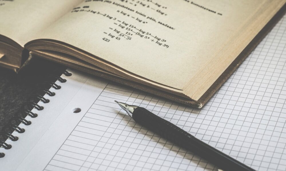 Блокнот, учебник и ручка на столе
