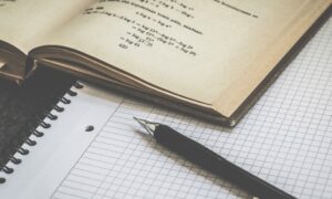 Блокнот, учебник и ручка на столе