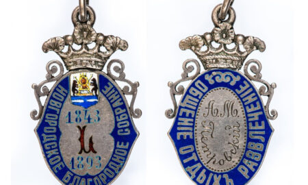 серебряный жетон на белом фоне