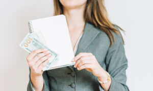 Девушка держит в куках деньги.