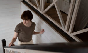 Девушка поднимается по лестнице в доме.