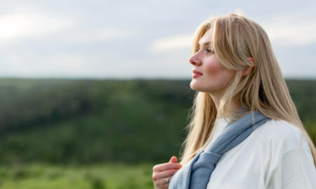 Девушка в белой футболке смотрит вдаль.