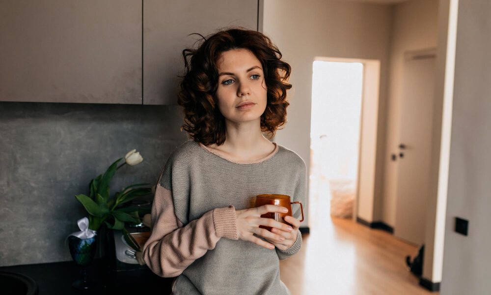 Девушка с чашкой кофе в уютной домашней обстановке.