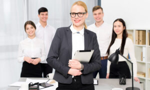 Женщина-руководитель и ее команда в офисе.