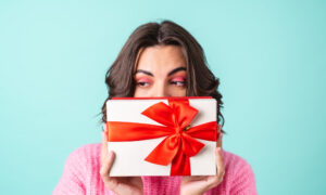 Девушка держит в руках коробку с подарком.