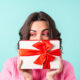 Девушка держит в руках коробку с подарком.