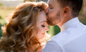 Влюбленная пара, мужчина целует женщину в лоб.