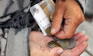 руки пожилого человека держат мелкие деньги