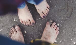 две пары босых ног в песке