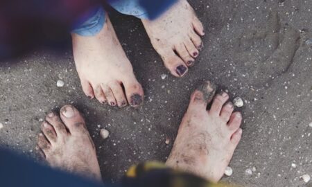 две пары босых ног в песке